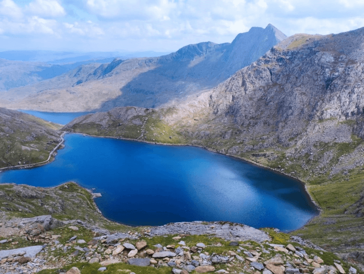 Views from high above Glaslyn, a bright blue lake set in dramatic stony scenery.