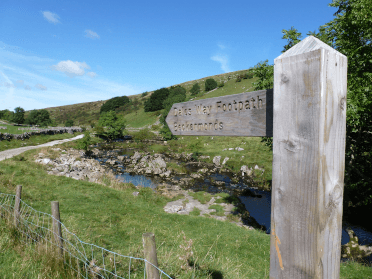 A fingerpost near Oughtershaw points out the line of the Dales Way along the river