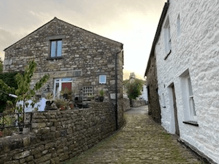 A cobbled street leads between old buildings in Dent.