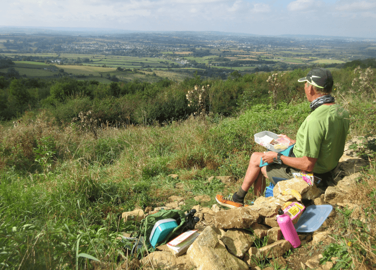 A walker sits on Prospect Hill as they eat their lunch from a protective tupperware box.