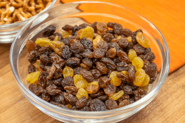 A glass bowl of raisins, the ideal dried fruit to bring on a walking holiday.